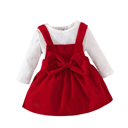 Red dress for baby girl with a large bow and white long-sleeve shirt on a white background