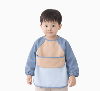 toddler boy wearing a blue and beige long sleeve bib