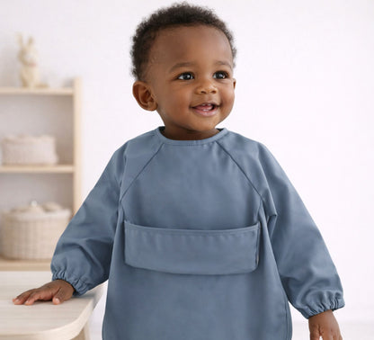 toddler boy wearing a blue feeding smock long sleeves