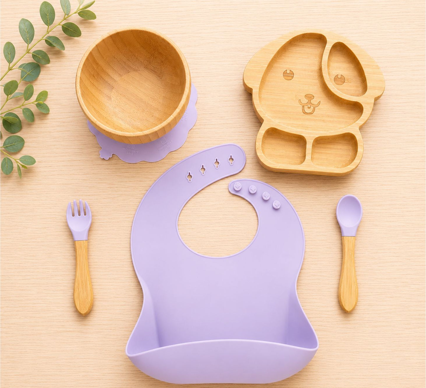 Organic bamboo dog-shaped baby feeding set, eco-friendly ,silicone bib, suction bowl, and wooden spoon and fork in purple colour.