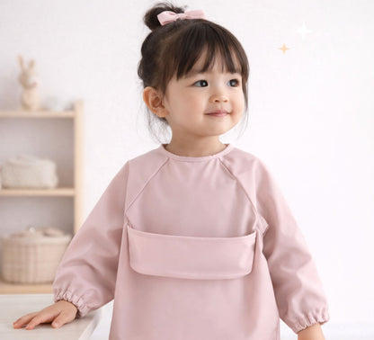 toddler girl wearing a pink feeding smock long sleeves