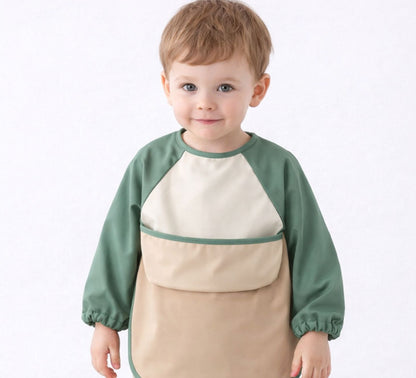 toddler wearing a green and beige long sleeve bib